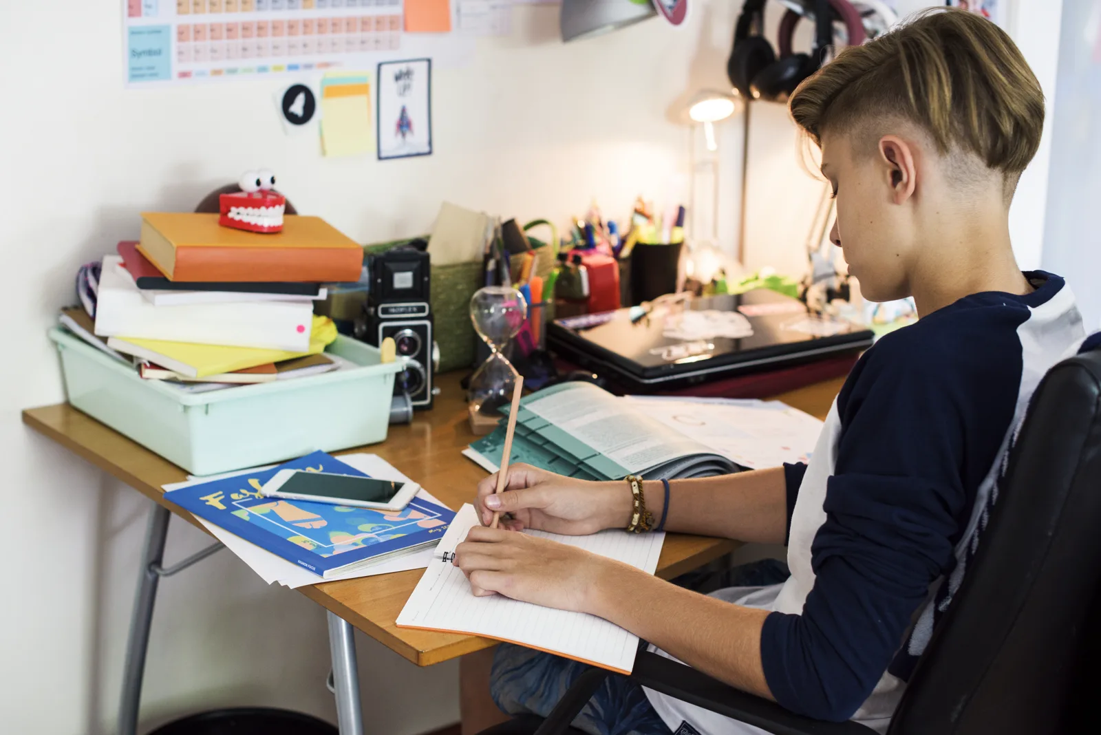 A student studying with notes at a tidy desk in a sunny room