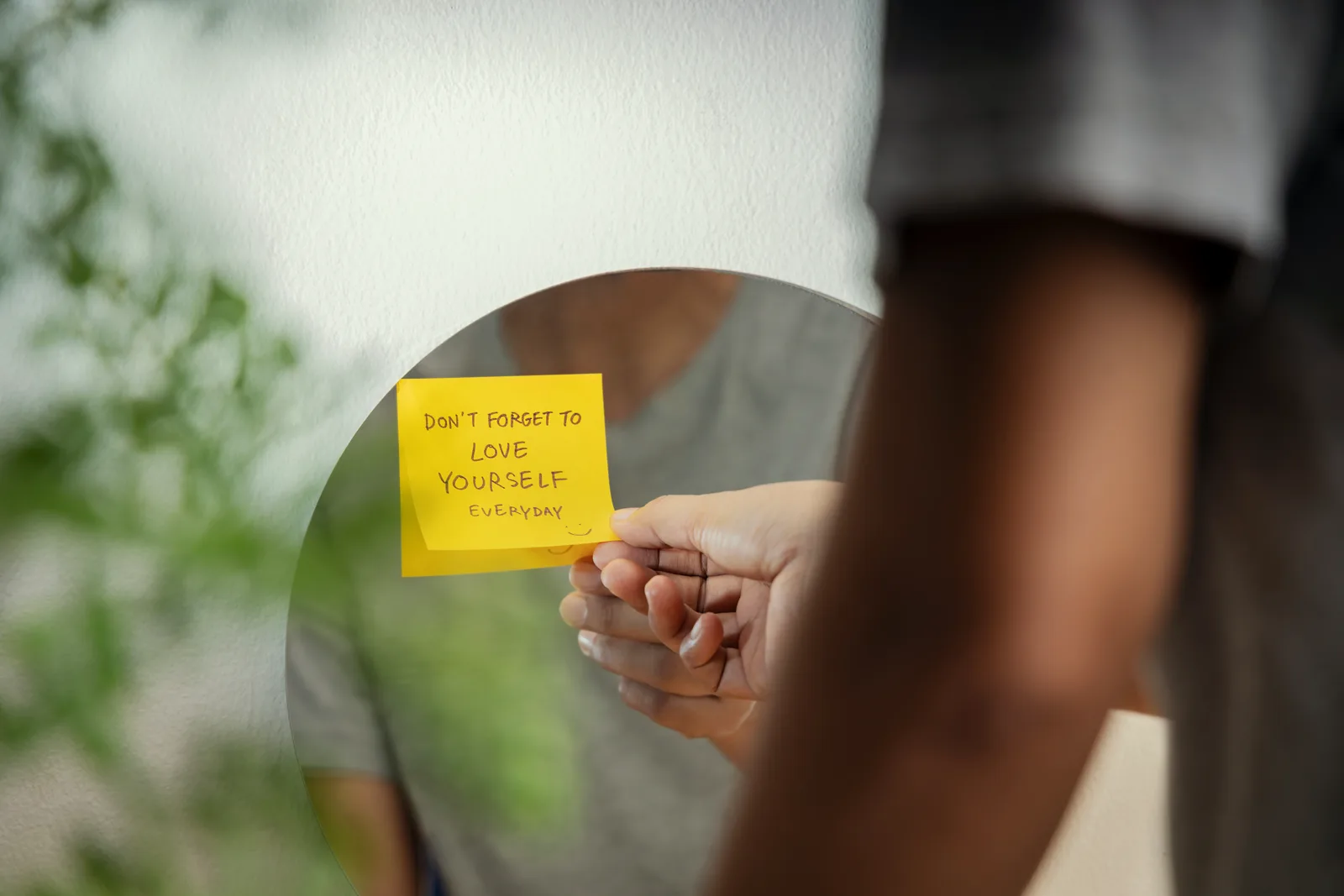 A small handwritten note tucked into the frame of a mirror in a softly lit room